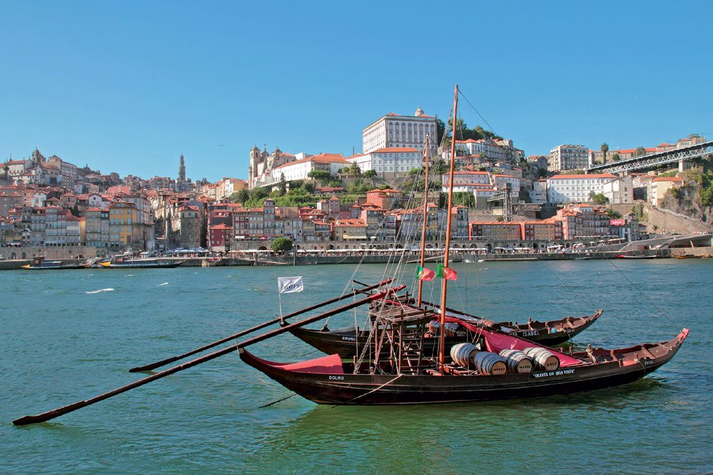 Stadt Porto und im Vordergrund der Fluß Douro mit zwei Boten.